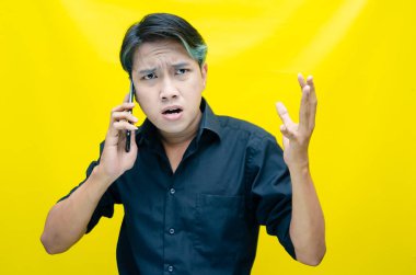 Akıllı telefonlu genç Asyalı adam duygusal konuşuyor. 