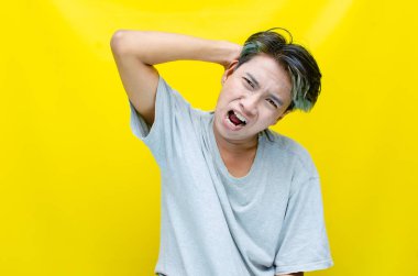 Asyalı genç adam sarı arka planda bağırıyor. iş kavramı üzerinde duruluyor.