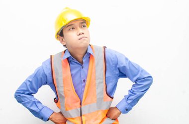 Sarı kask ve yelek giyen Asyalı inşaat işçisi 