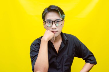 Sarı arka planda genç Asyalı bir adam 