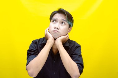 Sarı arka planda genç Asyalı bir adam 