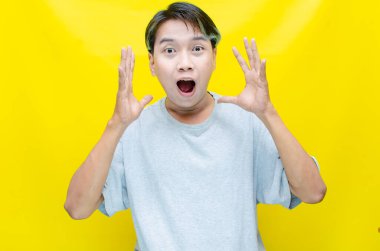 heyecan verici Asyalı genç adam yulaf sarısı arka plan 