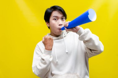 Anlamlı Asyalı adam kağıttan yapılmış bir megafona bağırıyor. 