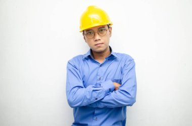 Asyalı genç adam sarı kaskı takıyor. 