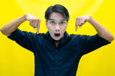 Sarı arka planda beliren Asyalı genç adamın portresi.