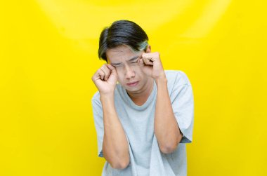 üzgün Asyalı genç adam stüdyo arka planında 