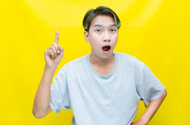 Genç Asyalı adam stüdyo geçmişini işaret ediyor. 