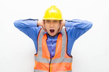 Sarı güvenlik kaskı ve yelek giyen Asyalı duygusal inşaat işçisi 