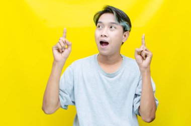 Genç Asyalı adam stüdyo geçmişini işaret ediyor. 