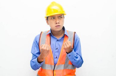 Sarı kask ve yelek giyen Asyalı inşaat işçisi 