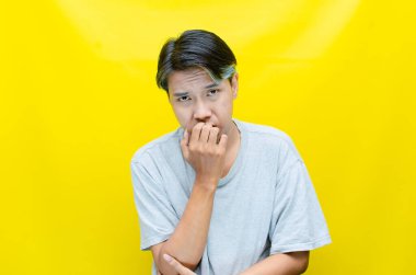 üzgün Asyalı genç adam stüdyo arka planında 