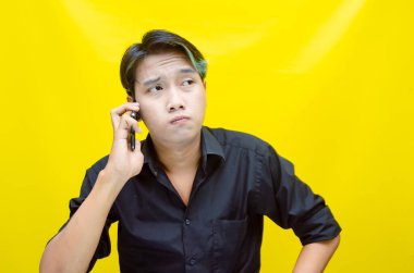 Akıllı telefonlu genç Asyalı adam duygusal konuşuyor. 