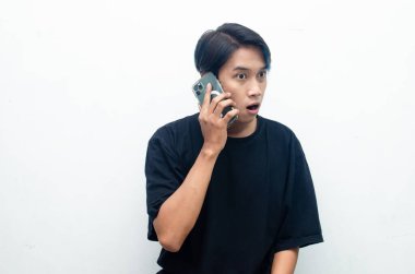 Genç Asyalı adam cep telefonuyla beyaz stüdyo geçmişi hakkında konuşuyor. 