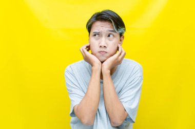 Sarı arka planda genç Asyalı bir adam 