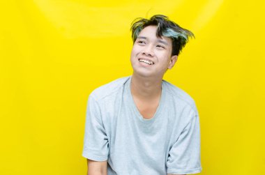 Beyaz arka planda tişörtlü mutlu Asyalı genç adam portresi