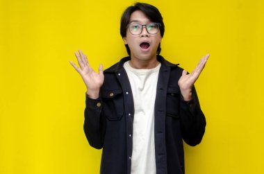 Sarı arka planda genç Asyalı bir adam var. 