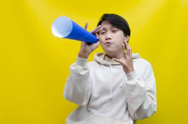 Anlamlı Asyalı adam kağıttan yapılmış bir megafona bağırıyor.