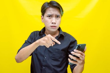 Duygusal Asyalı adam akıllı telefonunu kullanıyor. 