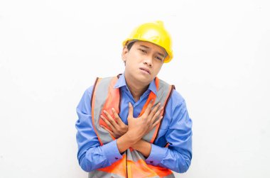 Sarı güvenlik kaskı ve yelek giyen Asyalı duygusal inşaat işçisi 