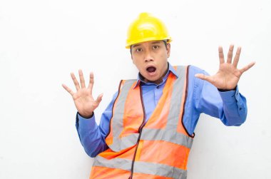 Sarı güvenlik kaskı ve yelek giyen Asyalı duygusal inşaat işçisi 