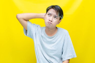 Sarı arka planda genç Asyalı bir adam 