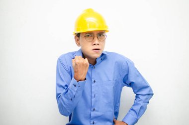 Asyalı kızgın inşaat işçisi sarı kaskı takıyor. 