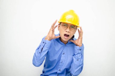 Asyalı kızgın inşaat işçisi sarı kaskı takıyor. 