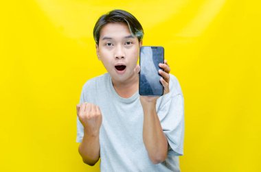 Stüdyoda akıllı telefonu olan genç bir Asyalı. 