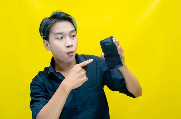 Akıllı telefon kullanan heyecanlı Asyalı genç adam. 