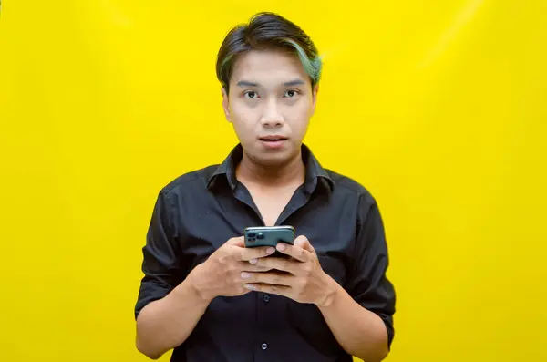 Akıllı telefon kullanan heyecanlı Asyalı genç adam. 