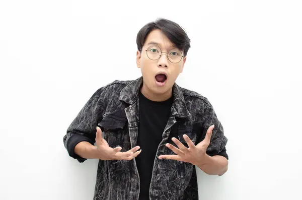 Gözlüklü mutlu Asyalı genç adam beyaz arka planda izole edilmiş bir şeyler sunmaktan mutluluk duyuyor. reklam panosu reklam modeli konsepti.