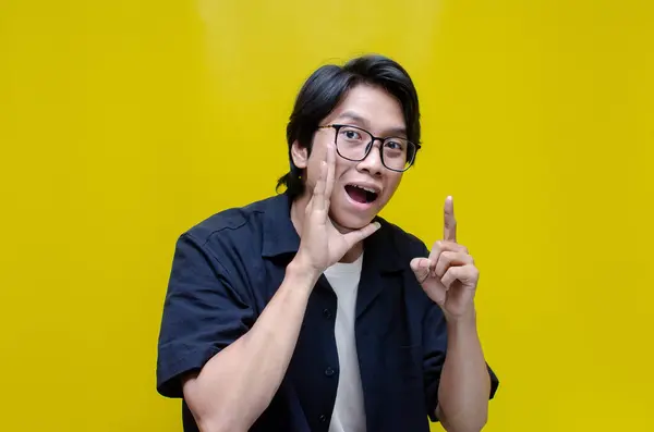 Stüdyodaki genç Asyalı adam fısıldıyor. 