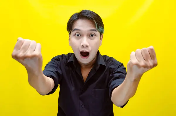 Heyecanlı Asyalı adam sarı arka planda 