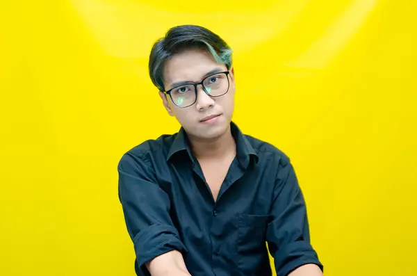 Sarı arka planda genç Asyalı bir adam 