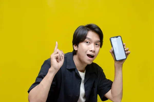 Akıllı telefonu olan neşeli Asyalı genç adam. 