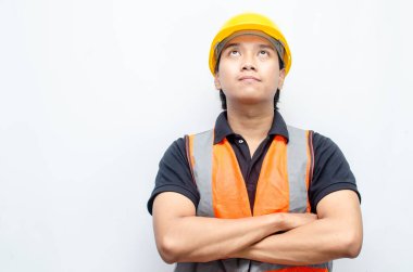 Asyalı kendine güvenen genç bir inşaat işçisi ya da mühendisinin portresi beyaz bir arkaplanda parlak bir gelecek görmek için ayakta duruyor. Parlak gelecek iş ve işçi konsepti.