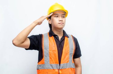 Beyaz Arkaplanda Sarı Miğferli ve Turuncu Yelekli Genç Asyalı İnşaat İşçisi