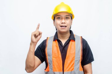 Siyah gömlekli ve sarı kasklı Asyalı mutlu inşaat işçisi reklamları gösteriyor.