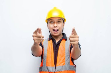 Siyah gömlekli ve sarı kasklı Asyalı mutlu inşaat işçisi reklamları gösteriyor.