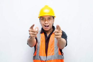 Siyah gömlekli ve sarı kasklı Asyalı mutlu inşaat işçisi reklamları gösteriyor.