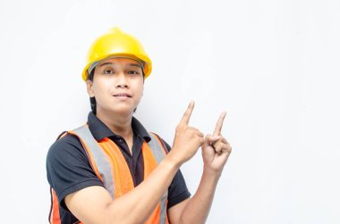 Siyah gömlekli ve sarı kasklı Asyalı mutlu inşaat işçisi reklamları gösteriyor.