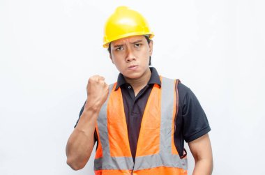 Asyalı inşaat işçisi, sarı sapkalı ve turuncu yelekli ve kaslı. Gücünü ve gücünü göstermek için. Güçlü İşçi Konsepti.