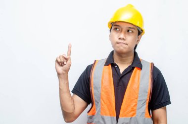 Siyah gömlekli ve sarı kasklı Asyalı mutlu inşaat işçisi reklamları gösteriyor.