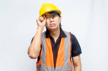 Beyaz Arkaplanda Sarı Miğferli ve Turuncu Yelekli Genç Asyalı İnşaat İşçisi