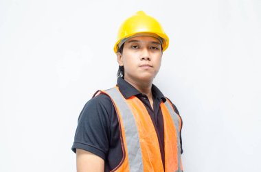 Asyalı kendine güvenen genç bir inşaat işçisi ya da mühendisinin portresi beyaz bir arkaplanda parlak bir gelecek görmek için ayakta duruyor. Parlak gelecek iş ve işçi konsepti.