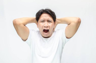 Genç Asyalı adam Çılgınca ve öfkeyle bağırıyor.