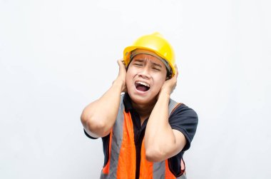 Asyalı Erkek İnşaat İşçisi 'nin Orange Vest ve Sarı Kasklı Kızgın, Kızgın, Üzgün, Kızgın İfadesiyle Aşırı Çalışmış Konsepti. 