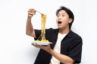 Siyah gömlekli genç bir Asyalı ve beyaz tişörtlü bir tabak kızarmış erişteli beyaz arka planda izole edilmiş. 