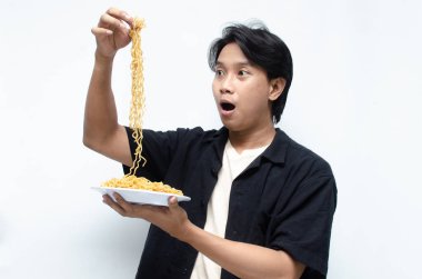 Genç Asyalı Adam Çıplak Elle Kızarmış Erişteyi Ağzına Çiğniyor. Çekici Asyalı adam Eriştelerin ne kadar lezzetli olduğunu gösteriyor..