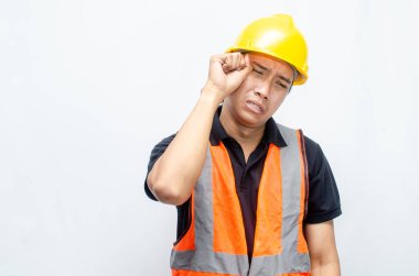 Beyaz Arkaplanda Sarı Miğferli ve Turuncu Yelekli Genç Asyalı İnşaat İşçisi